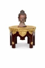 uddha Head Statue on Decorative Pedestal Table.